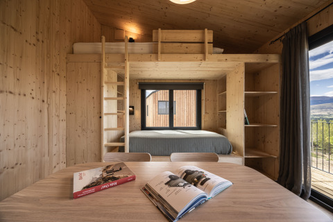 Cabina in legno moderna con letto a soppalco e ampie finestre, Basecamps - Cabins Girona glamping.