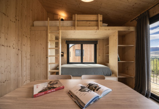 Moderne houten cabine met loftbed en grote ramen, uitzicht bij Basecamps - Cabins Girona glamping.