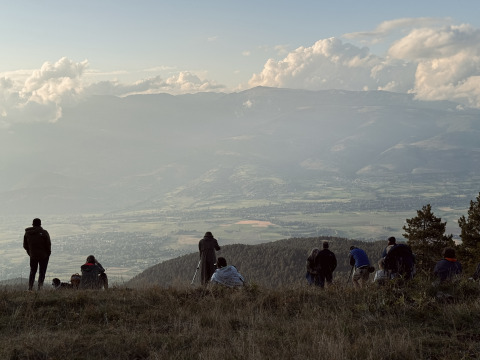 Mehrere Personen genießen den Panoramablick vom Hügel bei Basecamps - Cabins Girona in den Bergen.