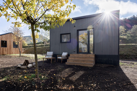 Alojamiento glamping Basecamps - Cabins Girona, cabaña moderna con terraza amueblada y entorno natural.