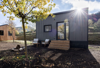 Alloggio glamping Basecamps - Cabins Girona, cabina moderna con terrazza arredata e ambiente naturale.