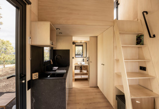 Interieur van Basecamps - Cabins Girona glamping met moderne keuken, trap en een sfeervolle badkamer.
