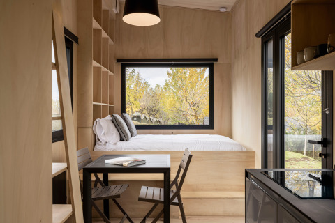 Moderne glampinghytte Basecamps - Cabins Girona med træinteriør, store vinduer og naturskøn udsigt.