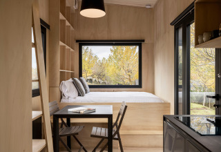 Moderne glampinghytte Basecamps - Cabins Girona med træinteriør, store vinduer og naturskøn udsigt.