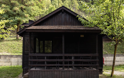 Donkerhouten huisje met veranda in een groene omgeving, Basecamps - Cabins Girona, glamping accommodatie.