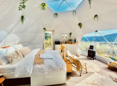 Binnenzicht van een luxe glampingkoepel bij Glamping Hohe Wand met warme inrichting en prachtig uitzicht.