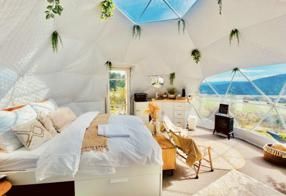 Binnenzicht van een luxe glampingkoepel bij Glamping Hohe Wand met warme inrichting en prachtig uitzicht.