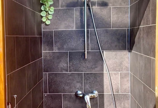 Ducha moderna con azulejos oscuros y tragaluz en Glamping Hohe Wand - De dome, alojamiento de camping o glamping.