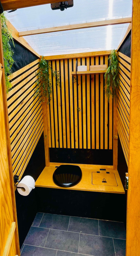 Baño ecológico con detalles de madera y plantas en Glamping Hohe Wand - De dome en los Países Bajos.
