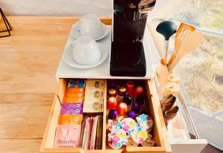 Coin café avec machine, tasses et dosettes organisées dans l’hébergement Glamping Hohe Wand - De dome.