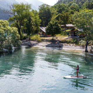 Glamping-oplevelse ved Camping Huttopia Lac de Serre-Ponçon, træhytter i skov og paddleboarding på søen.
