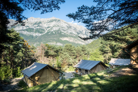 Glamping-Unterkünfte bei Camping Huttopia Lac de Serre-Ponçon in den Alpen von Haute-Provence mit Bergblick.