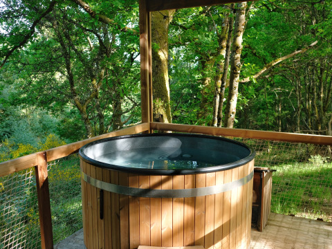 Bain à remous extérieur rond sur terrasse en bois, vue forêt, chez Nutchel - Lodges dans les Ardennes, Belgique.