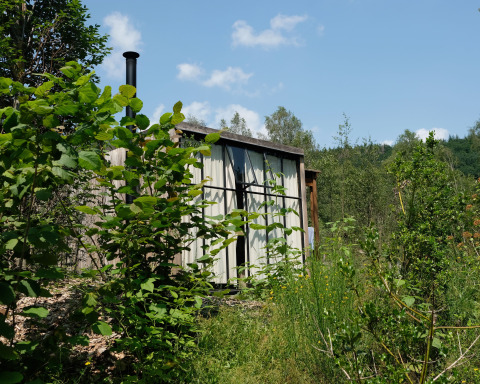 Hébergement glamping Nutchel Lodge dans les Ardennes, Belgique, niché confortablement dans la verdure.