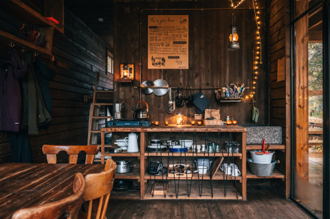 Sfeervolle glamping lodge in de Ardennen, België, met houten keuken, warme verlichting en natuurlijke sfeer.