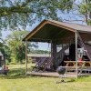Glamping accommodation at Domaine Bonneblond in Auvergne-Rhône-Alpes with lodge tents and BBQ grill.