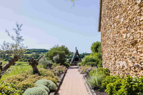 Beautiful stone building and garden walkway at Domaine Bonneblond Glamping Lodges in Auvergne-Rhône-Alpes, France.