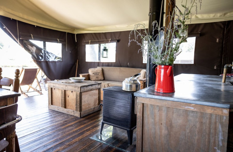 Interior of a glamping lodge at Domaine Bonneblond, Auvergne-Rhône-Alpes, featuring rustic wooden furniture.
