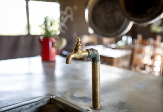Grifo de latón rústico en la cocina de la glamping Domaine Bonneblond en Auvernia-Ródano-Alpes, Francia.