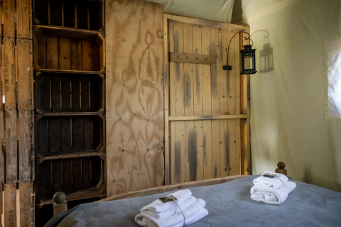 Interieur van tent bij Domaine Bonneblond Glamping Lodges Auvergne-Rhône-Alpes met hout en handdoeken.