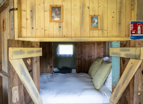 Sistemazione glamping accogliente al Domaine Bonneblond con letto e pareti in legno in Auvergne-Rhône-Alpes.