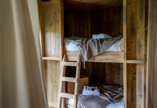 Rustikke køjesenge i træ på Domaine Bonneblond Glamping Lodges i Auvergne-Rhône-Alpes med hyggelig stemning.