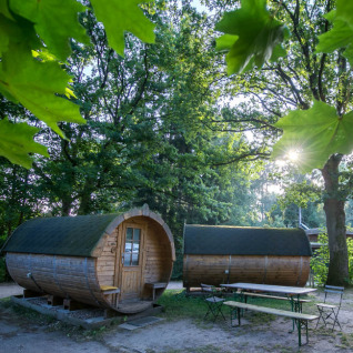 Hébergements glamping en pods en bois en forme de tonneau entourés d’arbres à Uhlenköper-Camp Uelzen.