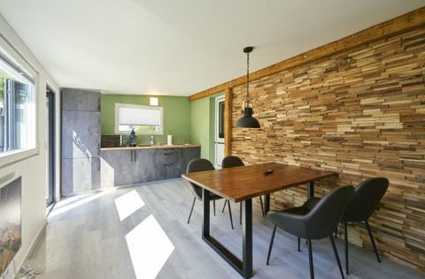 Moderne glampingaccommodatie met houten muur, eettafel en keuken bij Campingplatz Kirchzarten, Zwarte Woud.