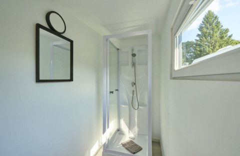 Cabina doccia moderna con grande finestra e specchio in glamping premium al Campingplatz Kirchzarten, Foresta Nera.