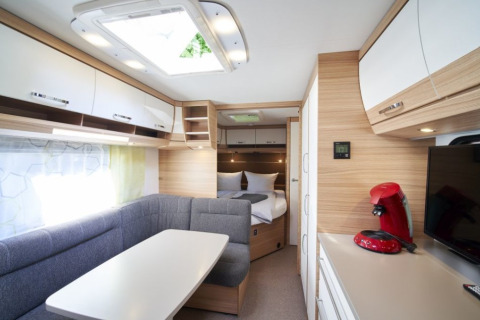 Hébergement glamping moderne au Campingplatz Kirchzarten avec coin repas, lit et machine à café.