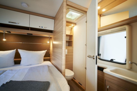 Modern glamping accommodation with a bed, bathroom, and storage at Campingplatz Kirchzarten, Black Forest.