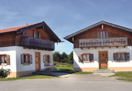 Two cozy wooden lodges at VITAL Camping Bayerbach in Bavaria, perfect for glamping and relaxing in the countryside.