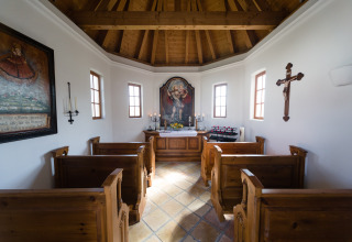 Interno accogliente di una chiesa con panche in legno e altare al VITAL Camping Bayerbach - Lodges in Baviera.