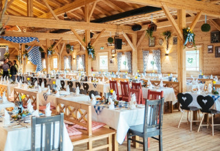 Sala da pranzo rustica al VITAL Camping Bayerbach - Lodges in Baviera, apparecchiata per un evento festivo.