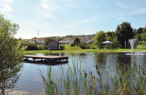 VITAL Camping Bayerbach, lodge in Baviera con lago, pontile, fontana e ampi spazi verdi naturali.