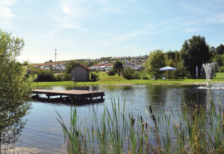VITAL Camping Bayerbach, con lodges en Baviera, lago, muelle, fuentes de agua y entorno verde y natural.