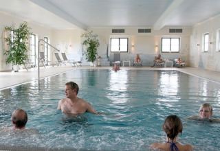 Binnenzwembad bij VITAL Camping Bayerbach - Lodges in Beieren met gasten die ontspannen en zwemmen.