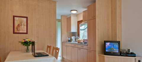 Moderne woon- en keukenruimte in stacaravan Orlando op Vakantiepark Havelberge, met eettafel aanwezig.