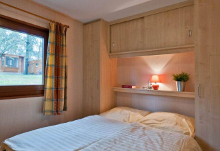 Vista interna di una camera da letto al Vakantiepark Havelberge - Stacaravan Orlando, con letto e finestra.