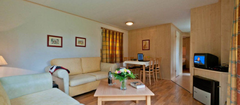 Vue intérieure du Vakantiepark Havelberge - Stacaravan Orlando avec salon confortable et coin repas.