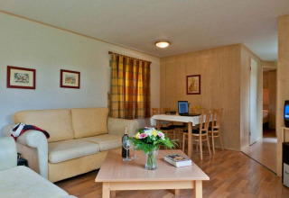 Vista interna di Vakantiepark Havelberge - Stacaravan Orlando con soggiorno accogliente e tavolo da pranzo.