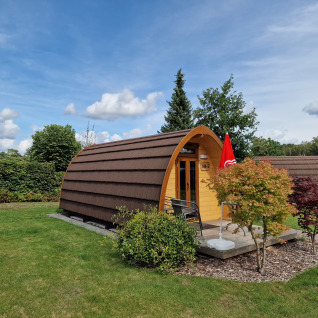 Alojamiento glamping en Campingplatz Auf dem Simpel, una acogedora cabaña en Lüneburger Heide, rodeada de verde.