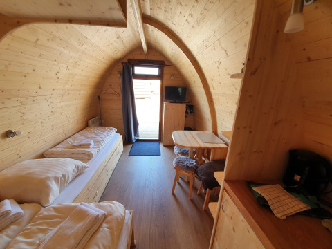 Glamping pod at Campingplatz Auf dem Simpel in Lüneburger Heide, with wooden interior, beds and table.