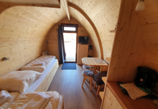 Glamping verblijf op Campingplatz Auf dem Simpel in de Lüneburger Heide met houten interieur en bedden.