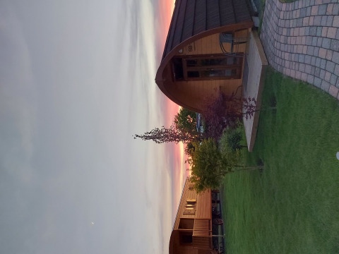 Hébergement glamping au Campingplatz Auf dem Simpel, Lüneburger Heide, pods en bois au coucher du soleil.