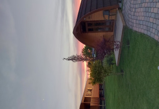 Glamping-Unterkunft Campingplatz Auf dem Simpel in der Lüneburger Heide, Holzpods bei Sonnenuntergang.