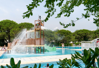 Vandlegeplads og swimmingpool omgivet af grønne træer på Camping Ca Savio - Nordisk Village telte i Venedig.