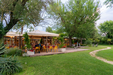 Area pranzo all’aperto al Camping Ca Savio - Nordisk Village tende Venezia immersa nel verde.