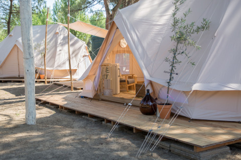 Glamping tents at Camping Ca Savio - Nordisk Village Venice, set on wooden decks in forested area.