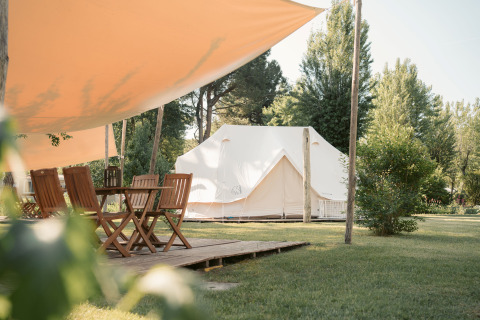 Glamping-Unterkunft mit Zelt, Holzmöbeln und Sonnensegel bei Camping Ca Savio – Nordisk Village in Venedig.